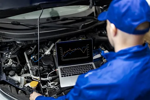 Bilmekaniker analyserar motordata med laptop